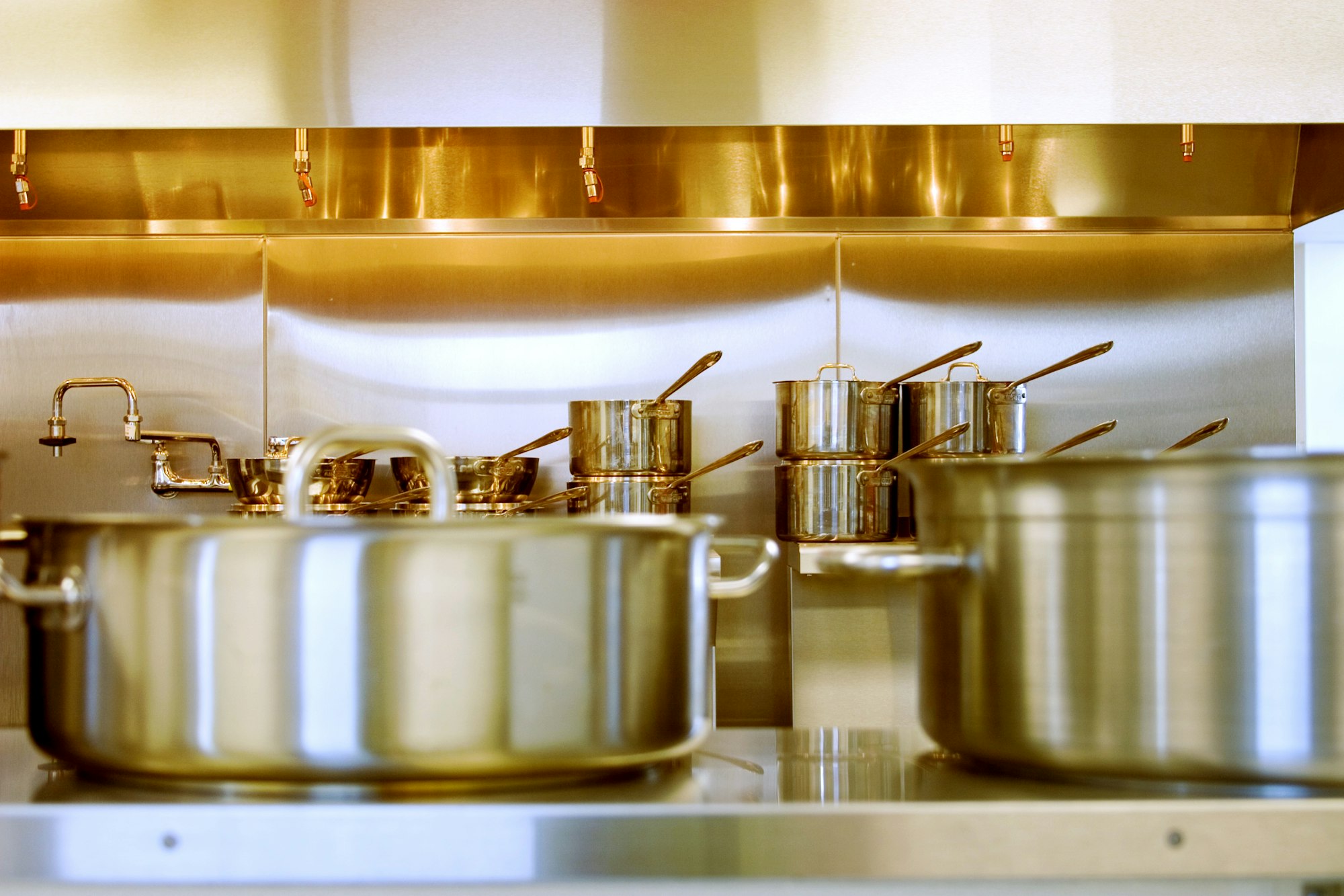 Polished stainless steel pots and pans in a professional kitchen